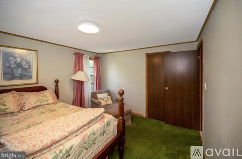 A bedroom with a floral bedspread and a wooden bed.
