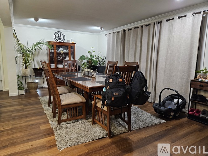 A living room with a glass table and chairs, a couch, a fireplace, and a bookshelf.