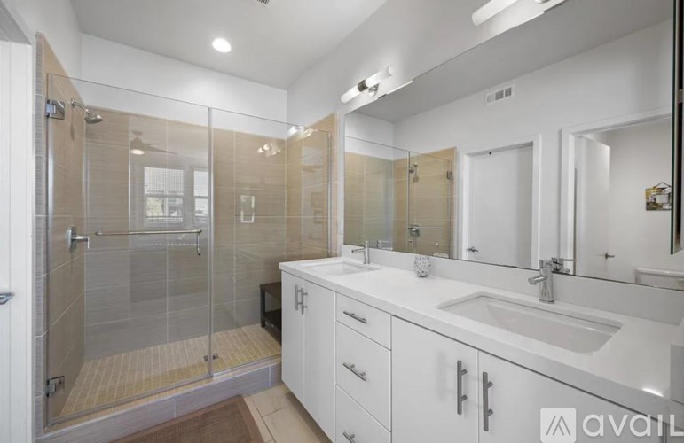 A bathroom with a walk-in shower and double sink vanity.