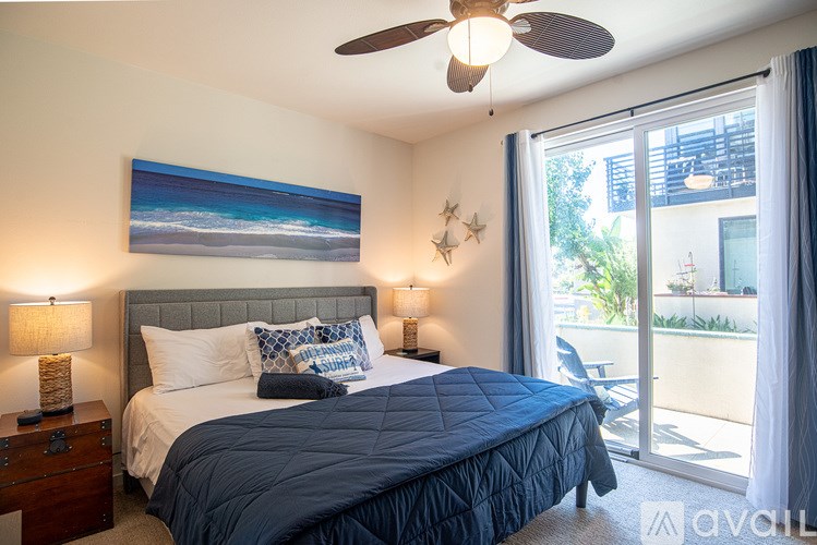 A bedroom with a large bed and a ceiling fan.