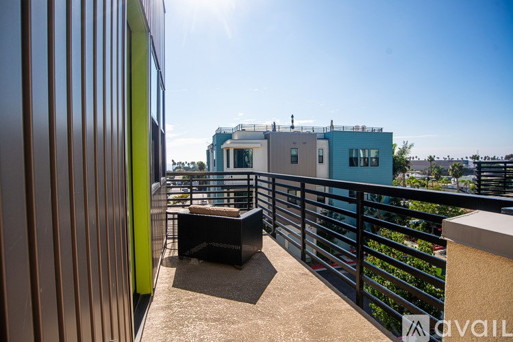 A balcony with a table and chairs overlooking a building.