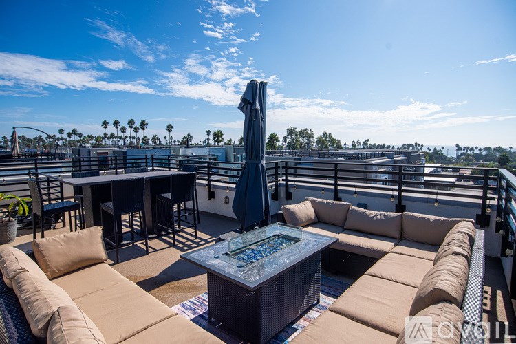 A patio with a table and chairs and a blue umbrella.