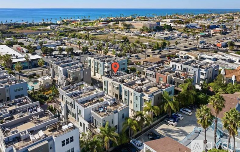 A red marker is placed on a building in a coastal city.