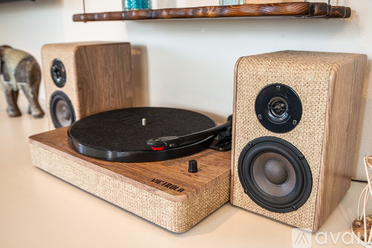 A record player with speakers on a wooden surface.