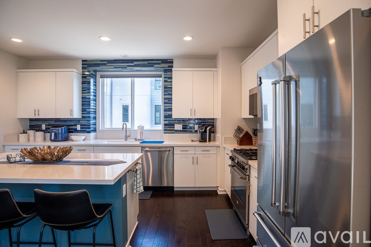 A modern kitchen with a large island and stainless steel appliances.