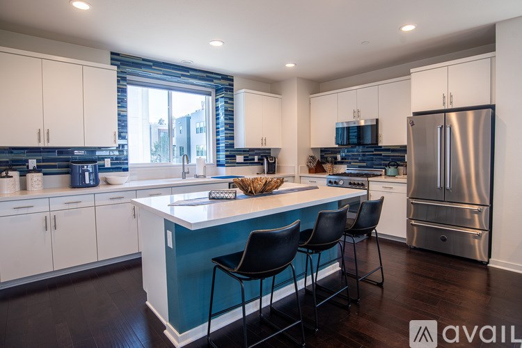 A kitchen with a blue island and white cabinets.