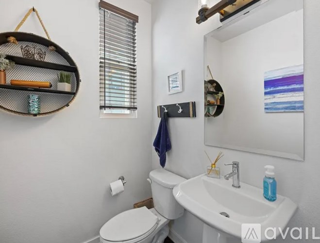 A bathroom with a toilet, sink, and mirror.