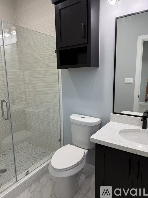 A bathroom with a toilet, sink, and shower.