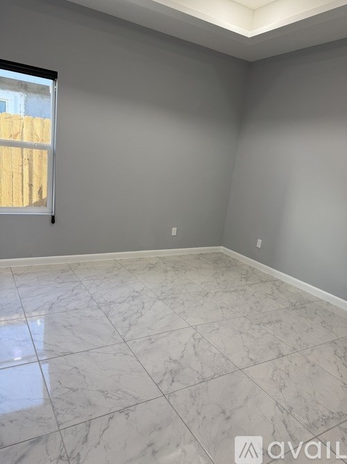 A room with a marble floor and a window.