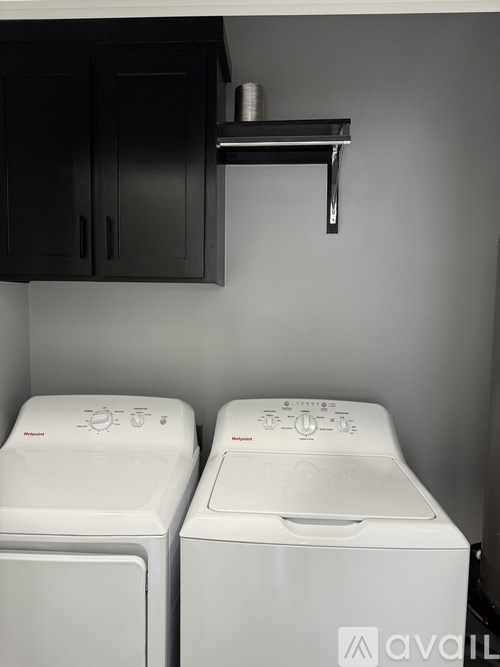 Two white front loading washing machines in a laundry room.