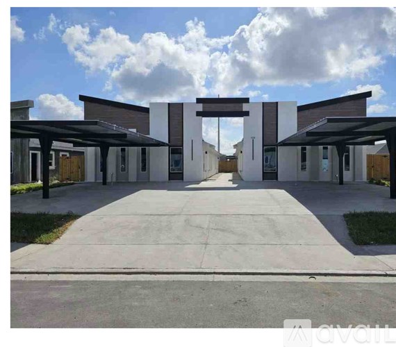 A modern building entrance with a large arched doorway and covered walkway.