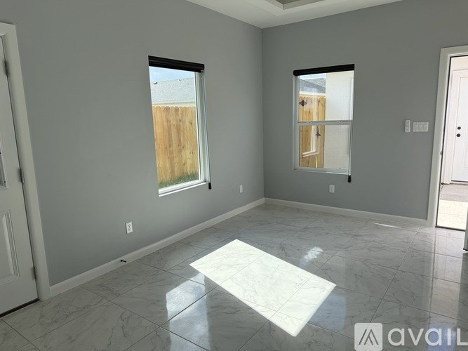 A room with a marble floor and a window overlooking a wooden fence.