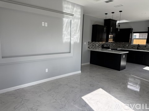 A kitchen with a black counter and a white wall.