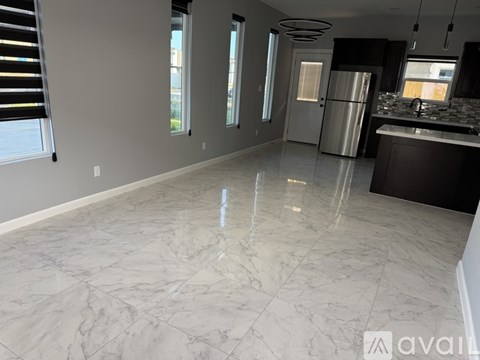 A kitchen with a marble floor and a refrigerator.