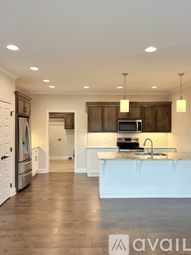 A modern kitchen with dark wood cabinets and white countertops.