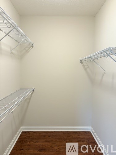 A bathroom with a white toilet and a wooden vanity with a sink and mirror.