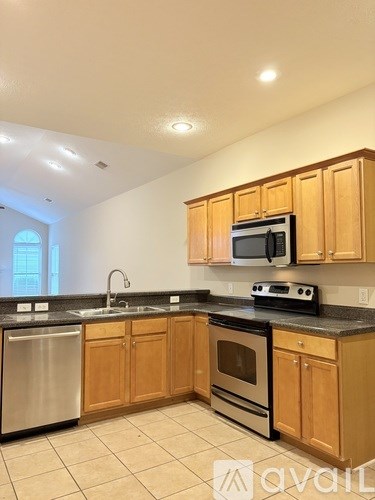 A kitchen with wooden cabinets and a blue island.