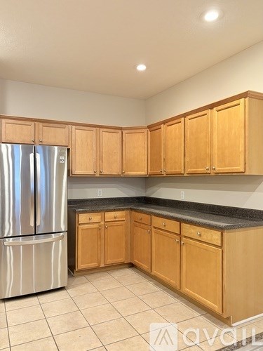 A kitchen with wooden cabinets and a granite countertop.