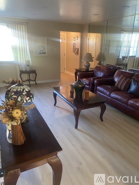 A living room with a brown leather couch and a wooden coffee table.