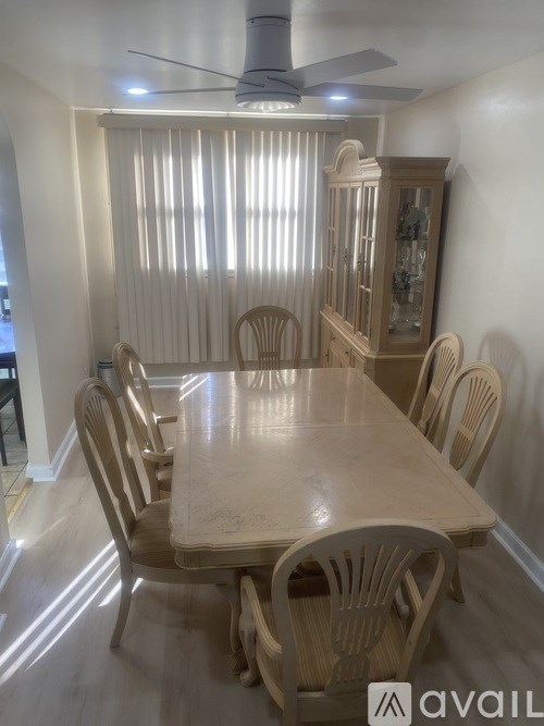 A dining room with a wooden table and chairs.