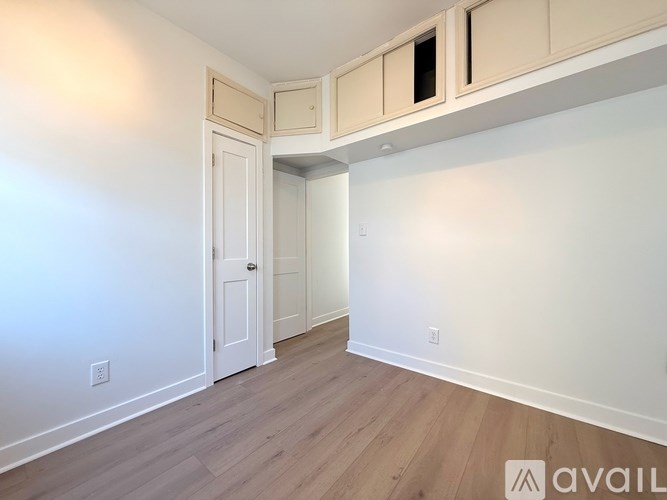 A room with a door and a cabinet above it.