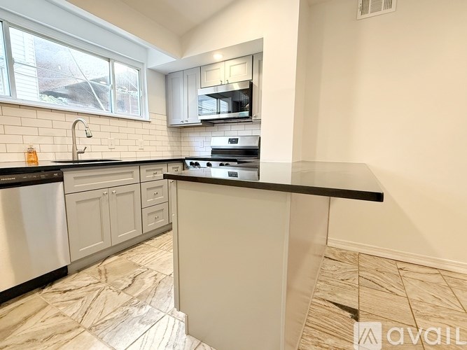 A kitchen with a black countertop and white cabinets.