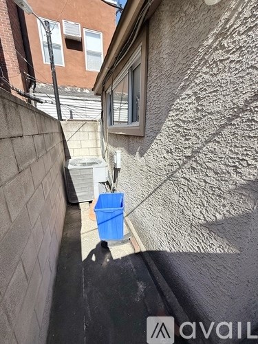 A blue bucket is placed on a concrete ledge.