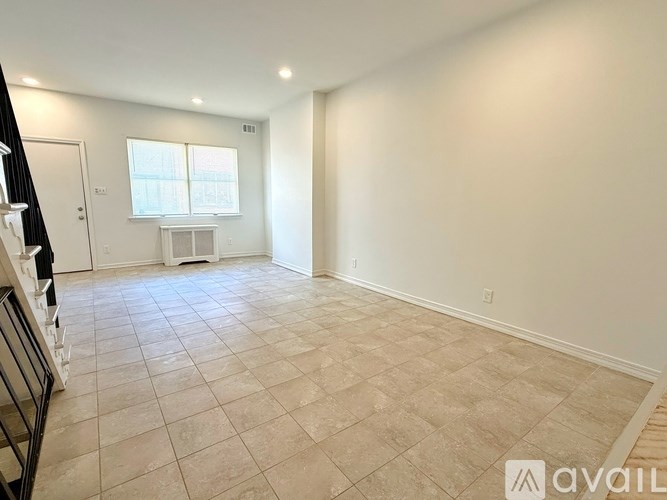 A spacious room with tiled flooring and a window.