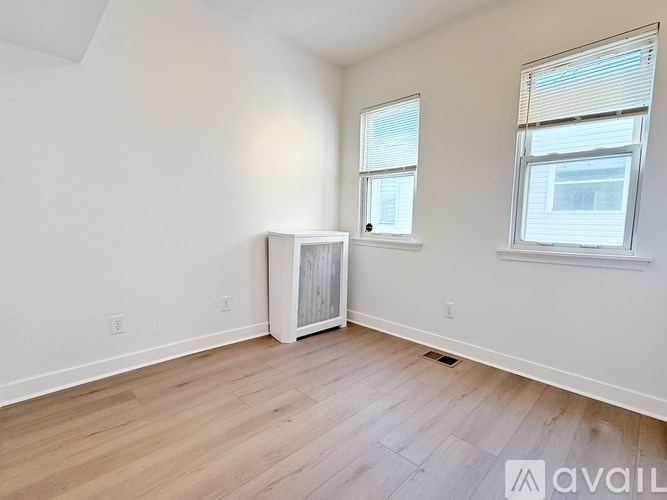 A room with a window and a door is available for rent.