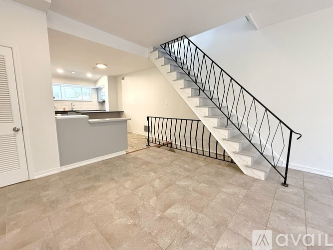 A staircase with a metal railing leads to a second floor.