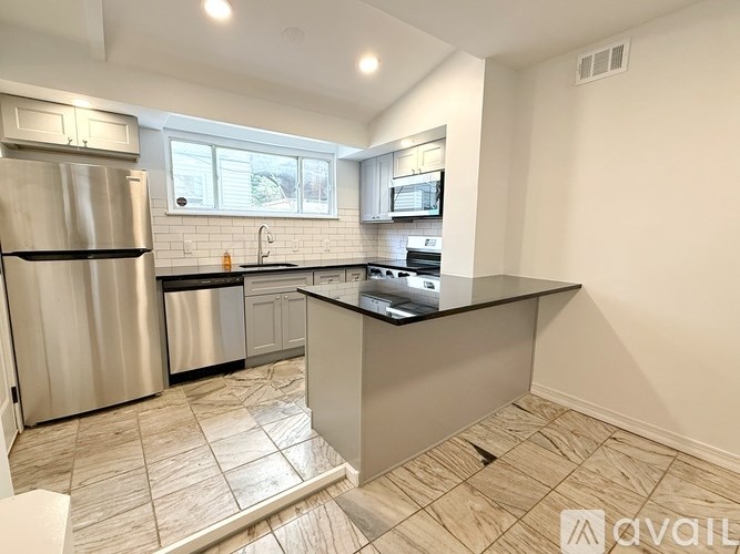 A kitchen with a refrigerator, sink, and countertop.
