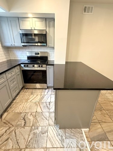 A kitchen with a stove top oven and microwave above it.