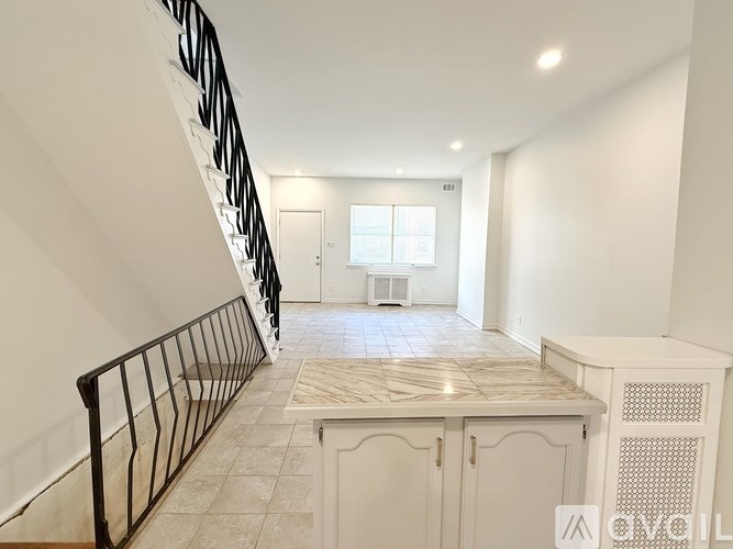 A staircase with a black railing leads to a room with a window and a door.