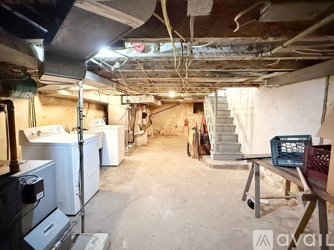 A dirty basement with a washer and dryer.