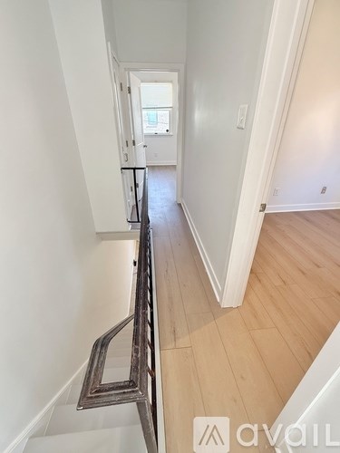 A long hallway with a wooden floor and white walls.