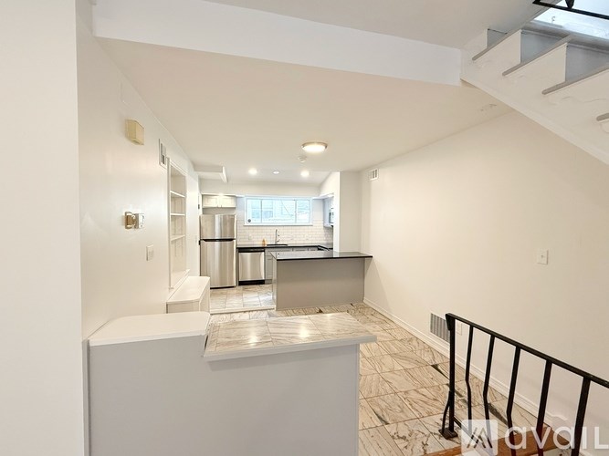 A kitchen with a stainless steel counter and a black railing.