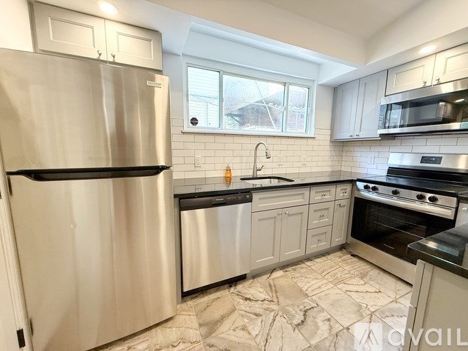 A kitchen with a stainless steel refrigerator and a black oven.