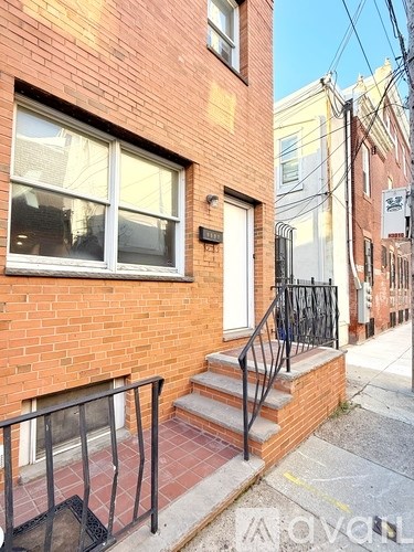 A red brick house with a black iron railing.
