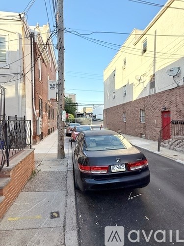 A black Honda car is parked on a street.