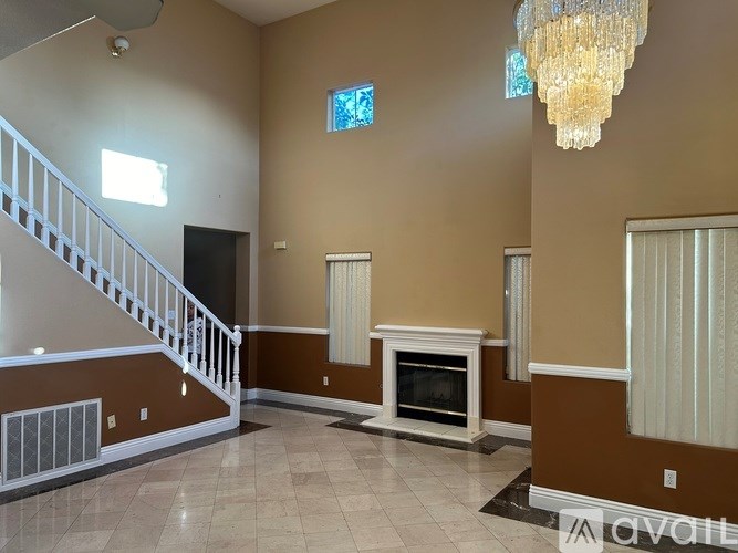 A living room with a fireplace and a staircase.