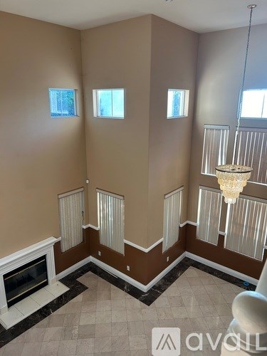 A living room with a fireplace and a chandelier.