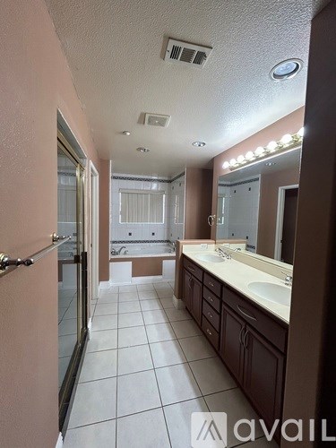 A bathroom with a sink, mirror, and a shower.