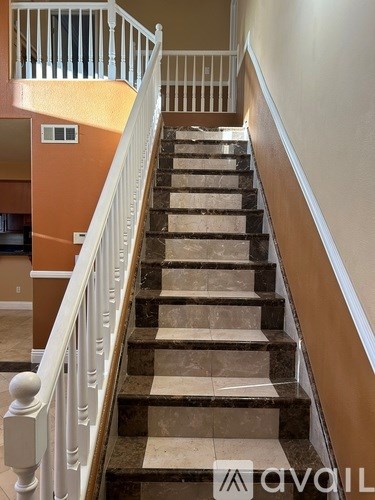 A staircase with a white railing and beige steps.