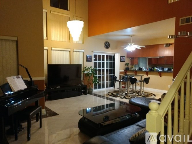 A living room with a piano and a television.