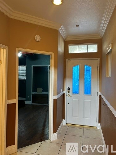 A living room with a glass table and a fan.