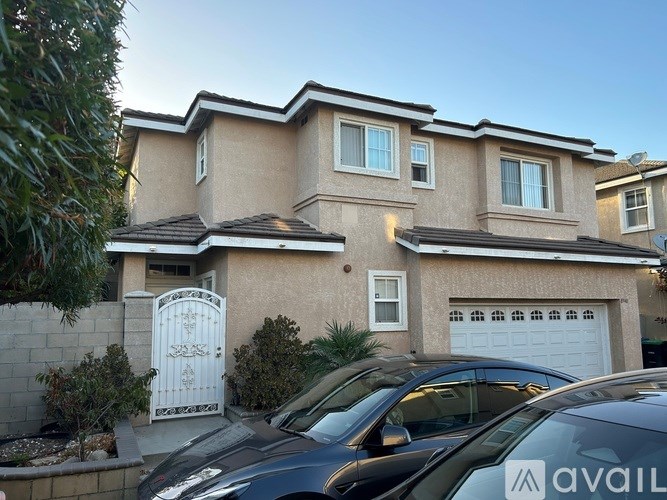 A living room with a black couch and a staircase.