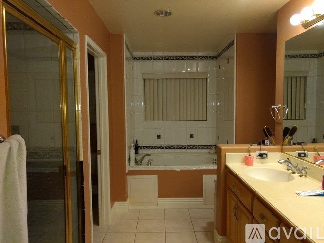 A bathroom with a sink, mirror, and bathtub.