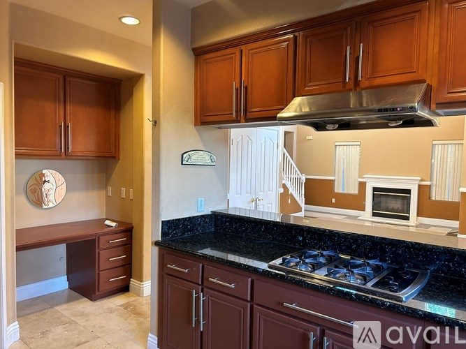 A kitchen with brown cabinets and a black granite countertop.