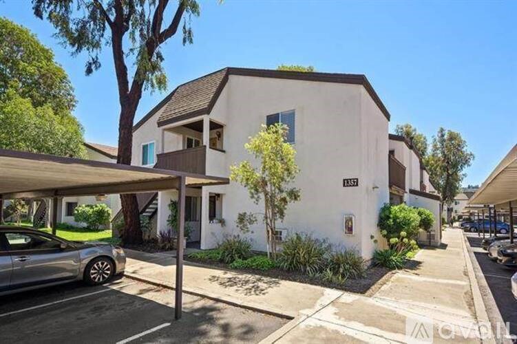 A white house with a car parked in front.