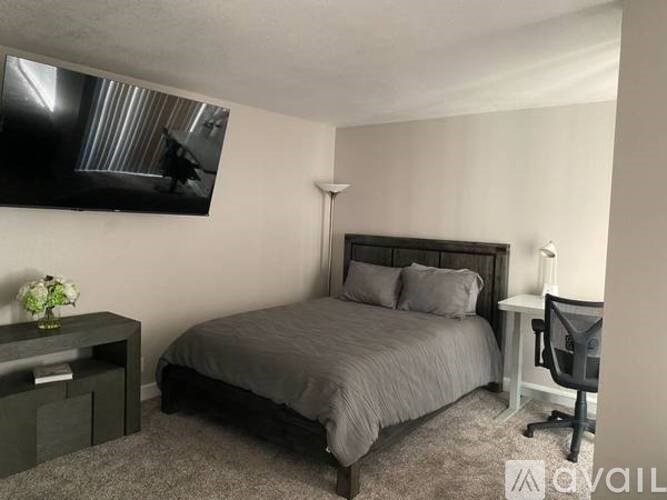 A bedroom with a bed, desk, and chair.